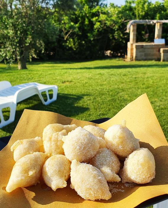 Sugary fritters served on paper, in a sunny garden.